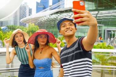 Şehirde yürüyen ve selfie çeken üç melez cinsiyet arkadaşı. Turizm ve tatil konsepti.