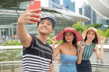 Kentte selfie çeken üç Asyalı arkadaş. Touri.