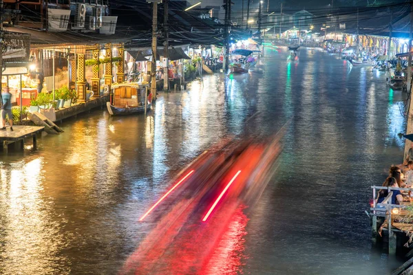 Trilhas leves de barco atravessando o rio em Amphawa noite flutuante — Fotografia de Stock