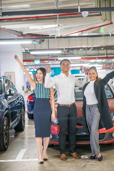 Tres felices amigos asiáticos sonriendo después de comprar un nuevo coche deportivo —  Fotos de Stock