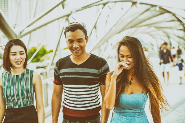 Tres jóvenes amigos asiáticos caminando y sonriendo por la ciudad — Foto de Stock