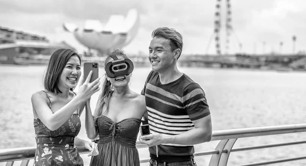 Trois asiatiques jeunes amis de plein air portant des lunettes vr et de prendre — Photo