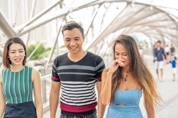 Trois jeunes amis asiatiques marchant et souriant autour de la ville — Photo