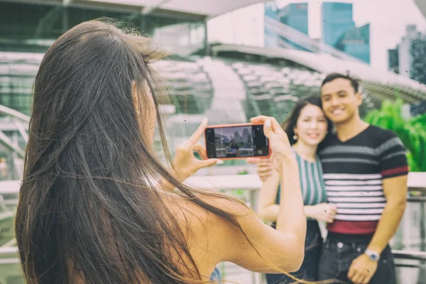 Menina bonita fazendo fotos de jovem casal asiático. Turismo um — Fotografia de Stock