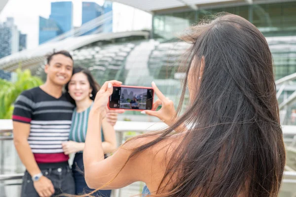 Menina bonita fazendo fotos de jovem casal asiático. Turismo um — Fotografia de Stock