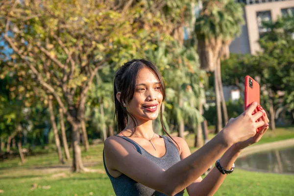 Hermosa mujer joven asiática relajándose y tomando selfies en la c — Foto de Stock