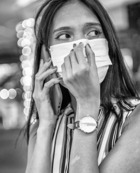 Młoda azjatycka kobieta z telefonem komórkowym i maską przeciwzanieczyszczającą powietrze — Zdjęcie stockowe