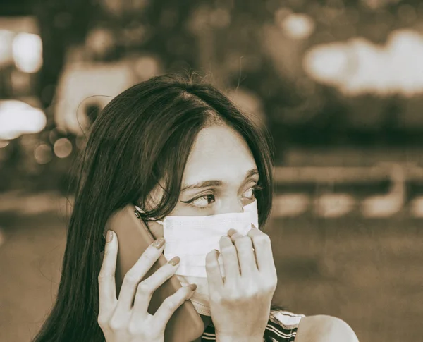 Młoda azjatycka kobieta z telefonem komórkowym i maską przeciwzanieczyszczającą powietrze — Zdjęcie stockowe