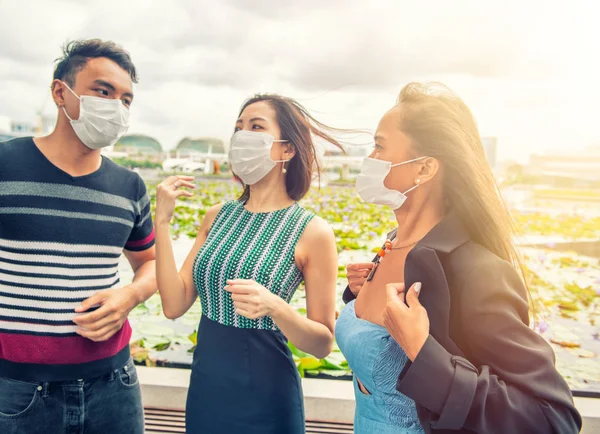 Groep van drie jonge Aziaten dragen maskers buiten. Luchttoevoer — Stockfoto