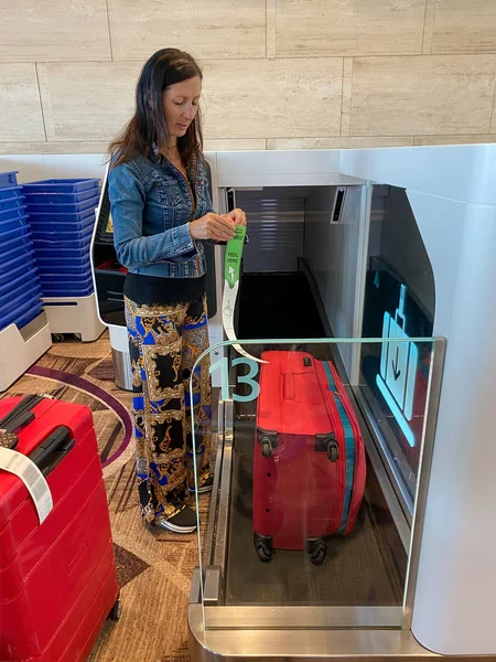空港での女性自動手荷物チェックイン手荷物へのタグ — ストック写真