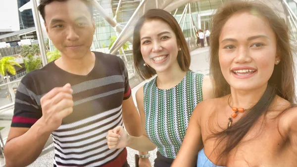 Τρεις ασιάτες φίλοι απολαμβάνουν υπαίθρια ζωή στην πόλη, λαμβάνοντας selfies. — Φωτογραφία Αρχείου