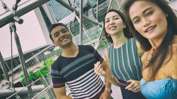 Tres asiático amigos disfrutando al aire libre ciudad vida tomando selfies. — Foto de Stock