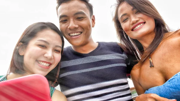 Τρεις ασιάτες φίλοι απολαμβάνουν υπαίθρια ζωή στην πόλη, λαμβάνοντας selfies. — Φωτογραφία Αρχείου
