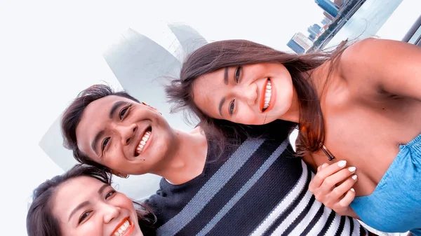 Three asian friends enjoying outdoor city life, taking selfies. — Stock Photo, Image