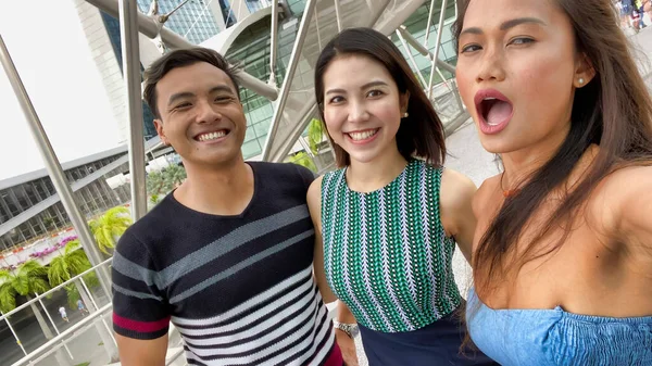 Tres asiático amigos disfrutando al aire libre ciudad vida tomando selfies. — Foto de Stock