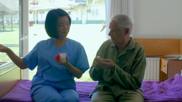 Beeldmateriaal Van Verpleegster Geven Pillen Aan Oudere Man Bejaardentehuis — Stockvideo