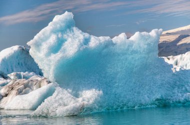 İzlanda, Avrupa. Jokulsarlon buzulu gölünde kış mevsiminde karla birlikte suda yüzen buzullar..