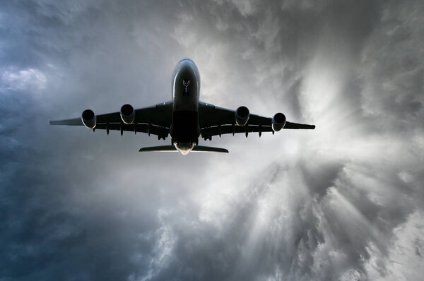 Airplane after take off from the airport, skyward view at sunset.