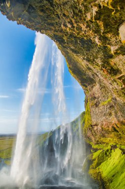 Seljalandsfoss Şelalesi yaz mevsiminde, İzlanda. Dağ ve mavi gökyüzü.