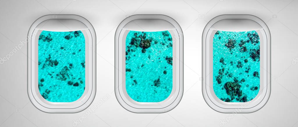 Airplane windows with Ocean Reef view. Travel and holiday abstract concept.