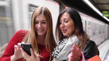 Barselona 'da birlikte vakit geçirirken akıllı telefon kullanan iki güzel kadın.