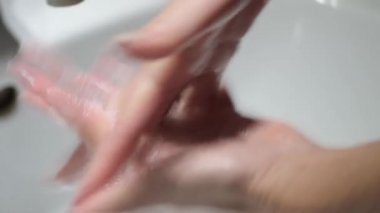 Kadın ellerini su ve sabunla iyice yıkıyor. Coronavirus önleme tedbirleri.