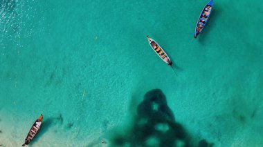 Tayland 'daki tropik bir sahil boyunca uzun kuyruklu teknelerin havadan görüntüsü..