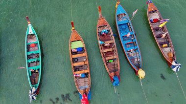 Tayland 'daki tropik bir sahil boyunca uzun kuyruklu teknelerin havadan görüntüsü..