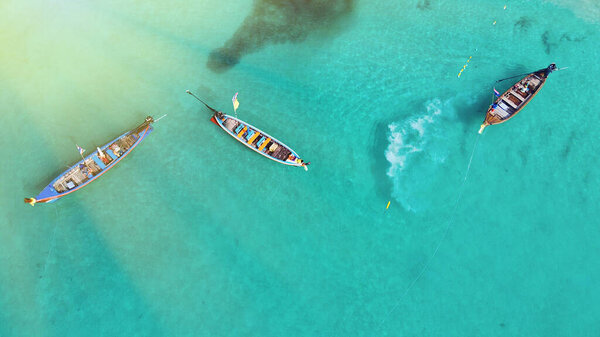Вид с воздуха на длинные хвостовые лодки вдоль тропического пляжа, Таиланд
.