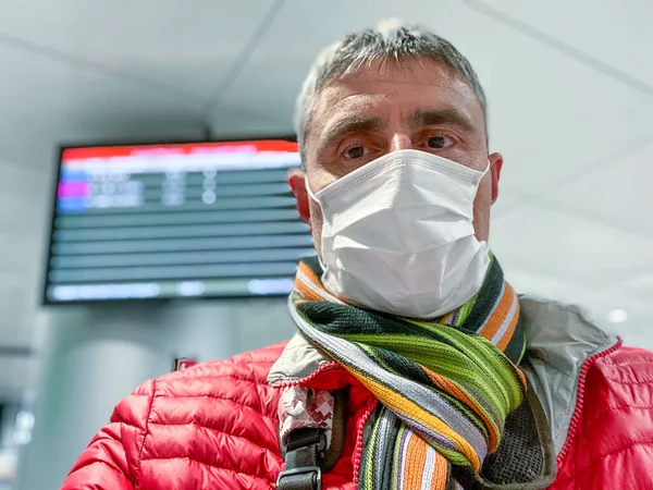 Man at the airport  in coronavirus times, wearing mask.