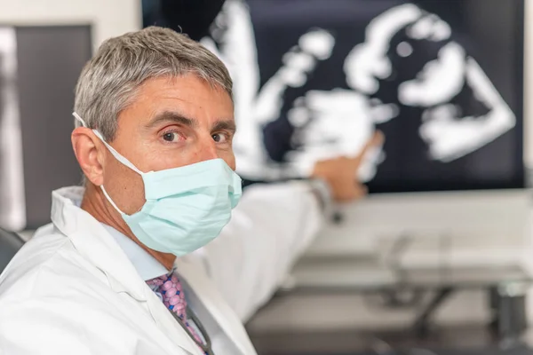 Médico Masculino Usando Máscara Analisando Dados Científicos Olhando Para Exibição — Fotografia de Stock