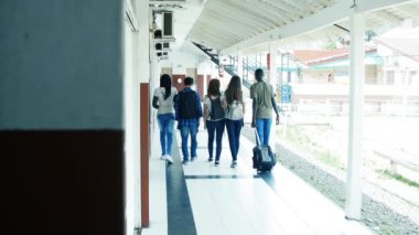 Okul koridorunda yürüyen bir grup öğrencinin görüntüleri.