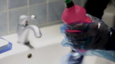 Evde banyo lavabosunu temizleyen kadın. Coronavirus önleme tedbirleri.