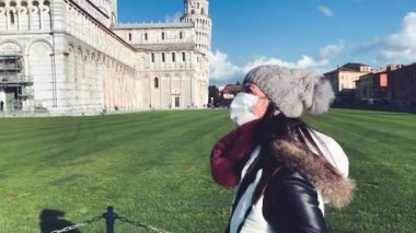 Sağlık maskesi takan kadın Mucizeler Tarlası 'nı ziyaret ediyor, Pisa.