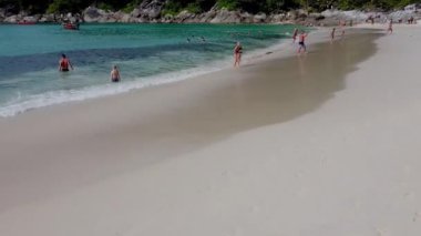 Güzel kumsaldaki taşlı ve ağaçlı insanların yukarıdan görünüşü