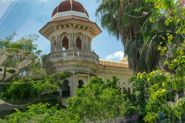 Ağaçlarla çerçevelenmiş eski Küba binası.