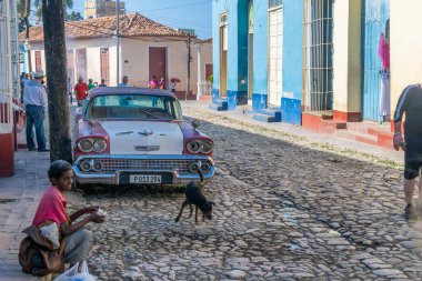 CUBA - 7 Nisan 2016: Turistler ve yerel halk, şehir sokaklarını tipik renkli binalarla ziyaret ediyorlar.