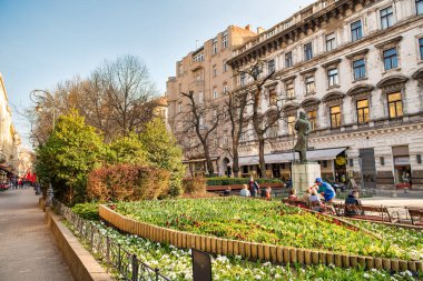BUDAPEST, HUNGARY - 30 Mart 2019: Turistler güzel güneşli bir günde Deak Ferenc Meydanı boyunca yürürler.