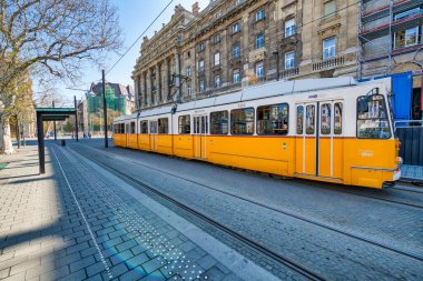 BUDAPEST, HUNGARY - 30 Mart 2019: eski sarı tramvay şehir caddeleri boyunca hızlanır. Macaristan 'ın tarihi merkezi..