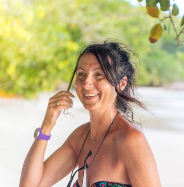 Güzel bir tropikal plaj boyunca duran bir kadın. Tatil ve tatil kavramı.