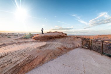 Horseshoe Bend, Page, AZ 'de gün batımını izleyen kadın..