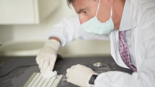 Läkare rengöring dator tangentbord bär handskar i coronavirus gånger — Stockvideo