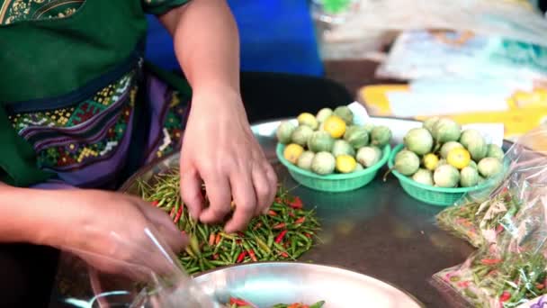 Mulher cortando pimenta vermelha em um mercado da cidade — Vídeo de Stock