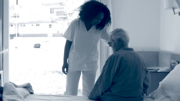 Pielęgniarka pomaga starszemu panu iść do szpitalnego łóżka. Sepia stonowana — Wideo stockowe