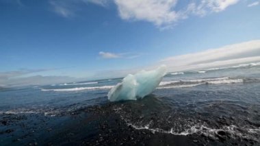 Jokulsarlon gölü, İzlanda. Yaz mevsiminde sahildeki buzdağlarının yavaş çekim görüntüsü