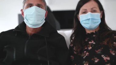 50 'li yıllarda anne babasıyla koronavirüs acil durumlarında yüz maskesi takan bir çiftin webcam görüntüsü. Aile zamanı, eğlenceli aktivite konsepti