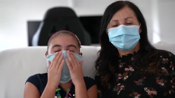 Webcam vista de la niña con madre durante un videocall con su padre en caso de emergencia coronavirus, ambos con máscaras. Tiempo en familia, concepto de actividad divertida — Vídeos de Stock