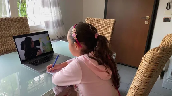 Avstandslæringskonsept. Skolegutt følger kurset på laptopen med læreren som forklarer leksjonen stockfoto