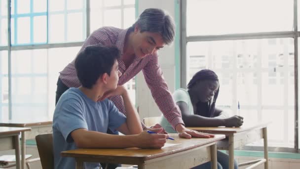 Profesor masculino revisando prueba de aula multiétnica — Vídeo de stock