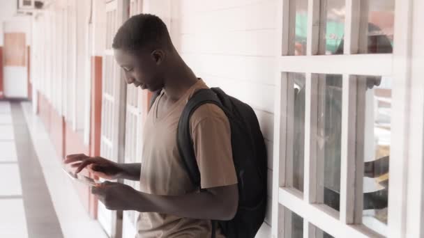 Afrikansk tonåring använder surfplatta utomhus i skolan — Stockvideo